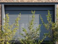 Geschlossende Raffstore-Jalousie vor Holz-Aluminium-Fenstern